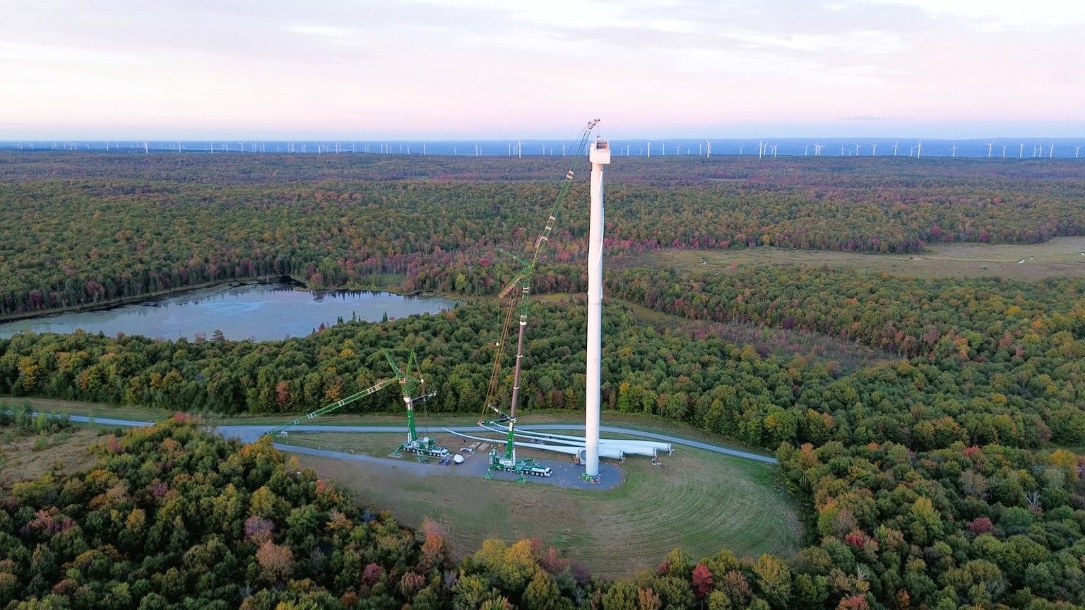 Tower erection with crane support in a forest landscape